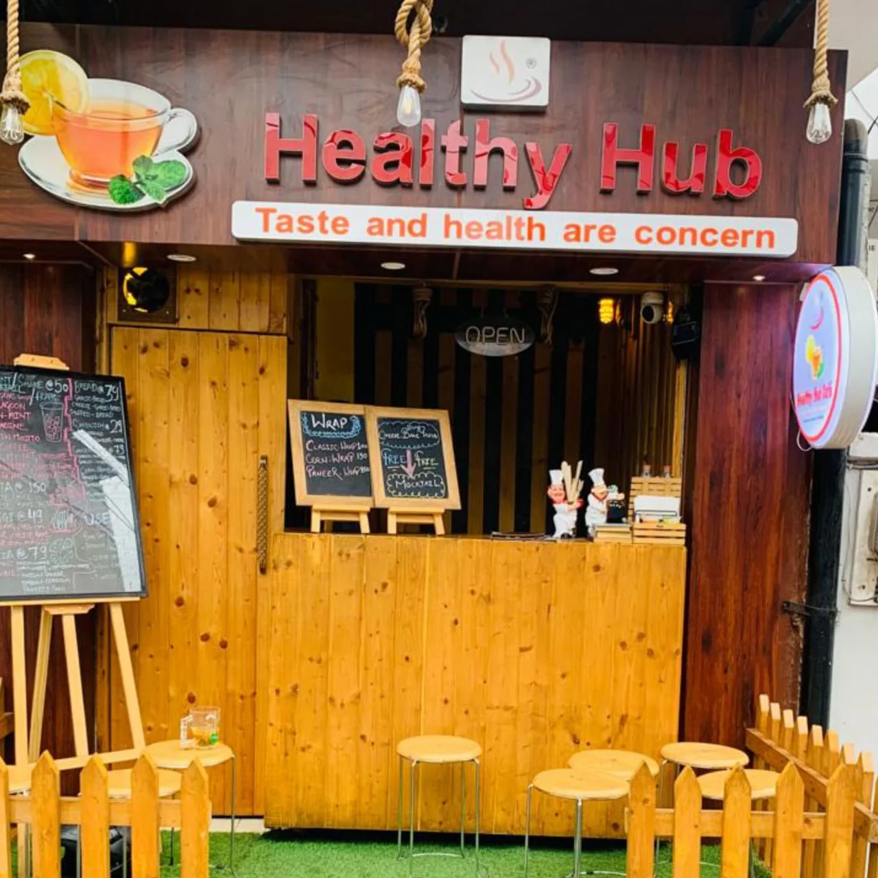 Healthy Hub Govind Nagar storefront with a wood counter and outdoor seating