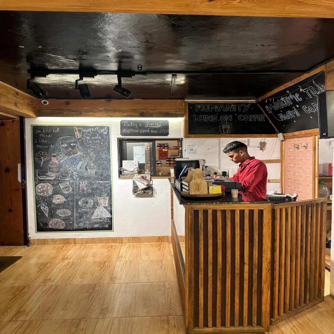 Ancient Sip café counter with a menu board and wood paneling