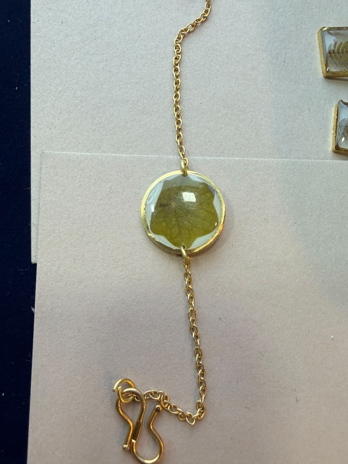 Cord bracelet with a round botanical resin centre
