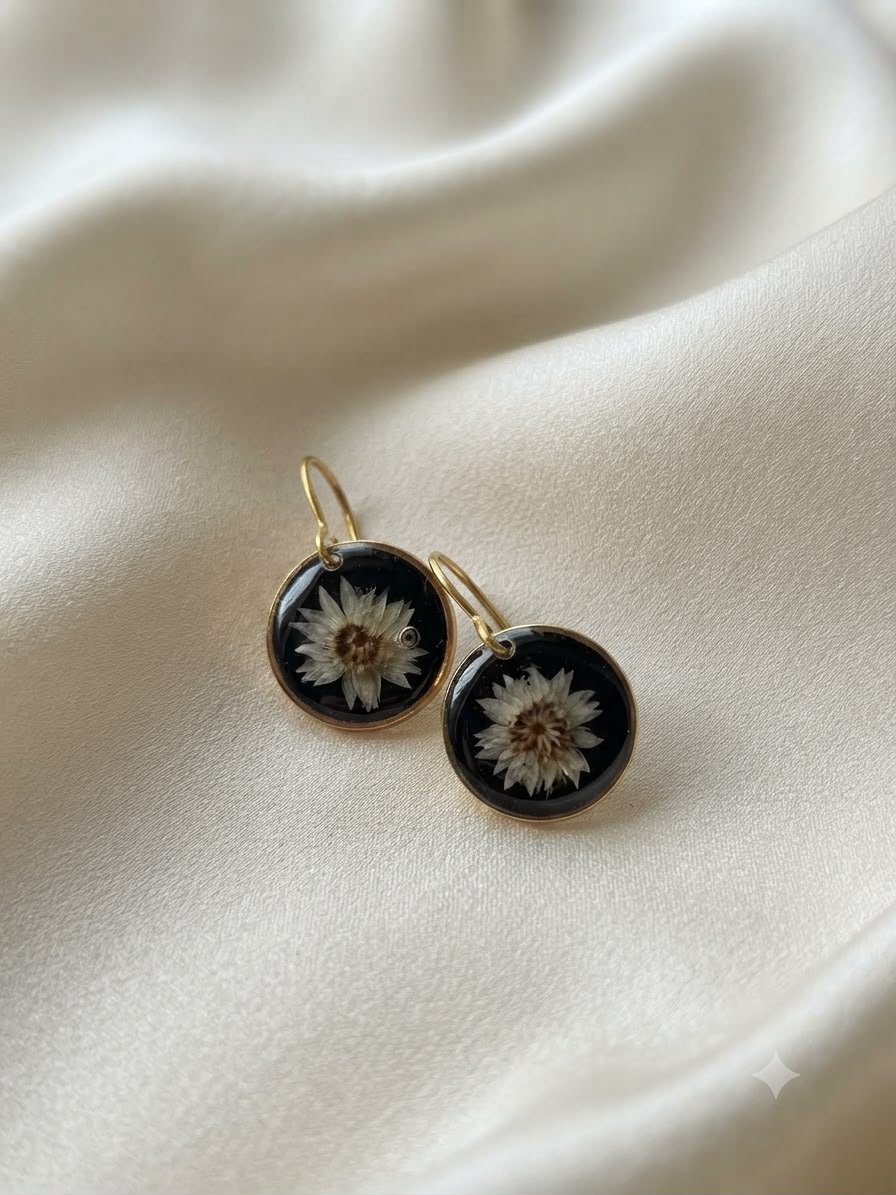 Round dark resin earrings with small dried flowers