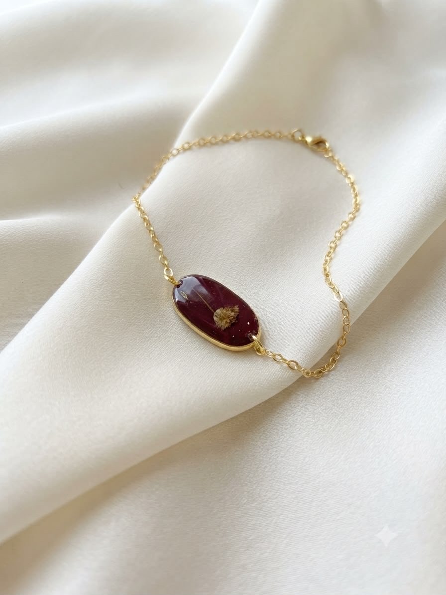 Burgundy resin necklace pendant with a dried flower